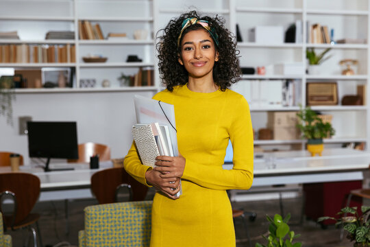 Smiling woman looking at camera in modern office