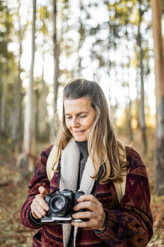 mature woman taking photos in nature