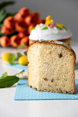 Easter brioche with swiss meringue and spring decoration, orange tulips on background. Happy Easter. Recipe of Easter bakery. Festive pastry for spring holidays.