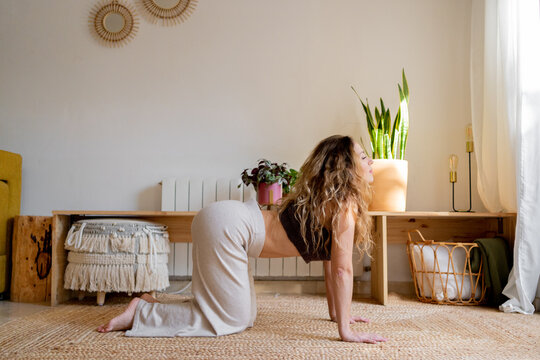 Young woman practicing yoga postures at home