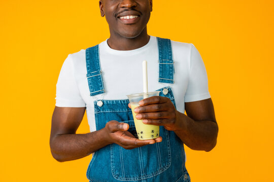 Anonymous crop Black man smiling while posing with  bubble tea