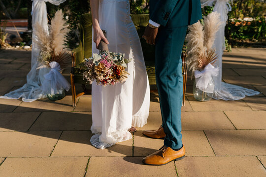 Crop bride and groom in garden