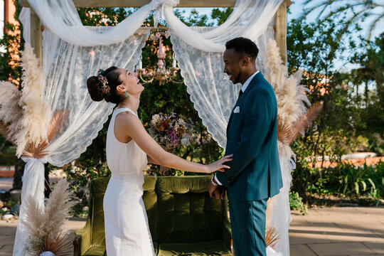 Happy diverse newlyweds in garden