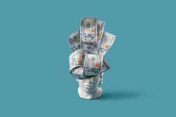 Dollars sticking out of ceramic head figurine.