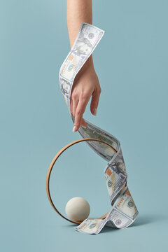 Long dollar curling around hand and metal ring.