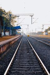Obraz premium railway platform or station with track, cable line goes above the rail line to pass electricity, Metal railway track in india, metal track for train in india, travel and transportation concept.