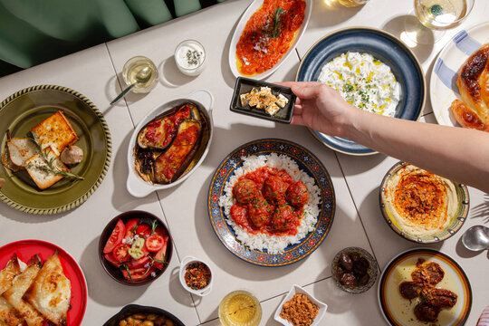 Serving feta cheese on the table full of traditional Greek foo