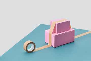 Pink parcels stuck with tape to blue table.