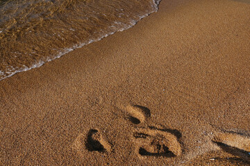 Close up view of the golden sandy beach and the clear waters of Mylopotas in Ios Cyclades Greece