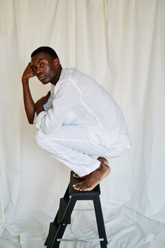 Man posing on small stairs.