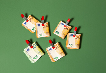 50 and 100 euro notes clipped together on a green background