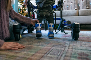 Child Using Boots And Walker To Learn To Walk
