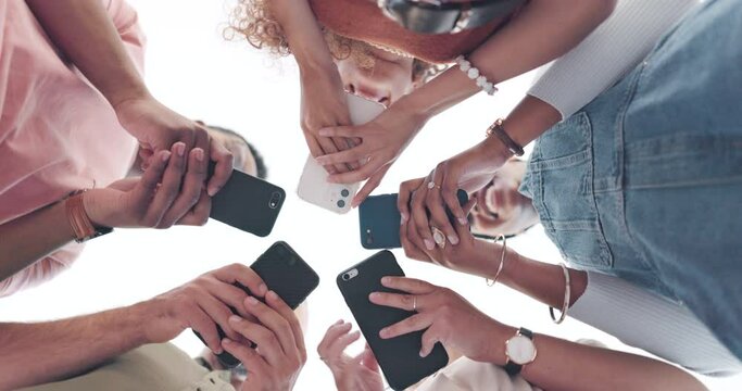 Hands, phone and networking with friends standing in a huddle or circle from below for communication. Social media, mobile and 5g with a man and woman friend group connected to the internet together