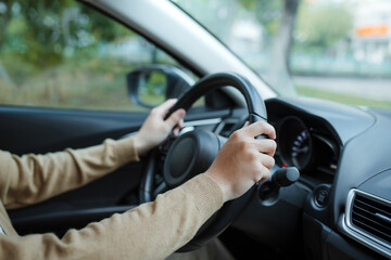 Male driver hands holding steering wheel