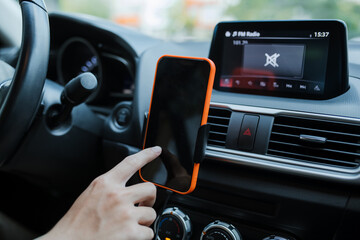 Male hand and smartphone in a car