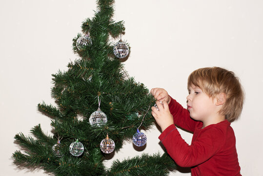 Boy decorates Christmas tree