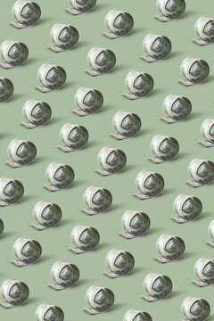 Pattern of repeated rolled 100 dollar banknotes.