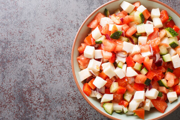 Bahamian conch salad is a vibrant and crunchy salad made using raw pound conch meat and vegetables closeup on the plate on the table. Horizontal top view from above