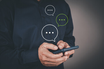 Man hand using smartphone chatting conversation working at home in chat box icons pop up, communication online.