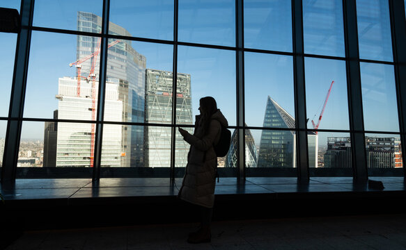 Woman Using Phone In Modern Architecture Background