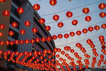 Red chinese lanterns hanging on wire outdoor lamps in temple of China Town decoration on Chinese New Year festival culture with blue sky at night background in Asia.