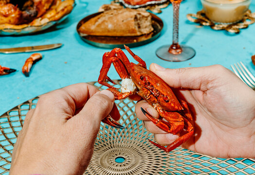 man ripping off the claw of a crab