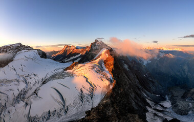 Glacier and mountain in the alps at sunrise aerial. 