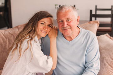 Older mature father and grown millennial daughter laughing embracing, caring smiling young woman...