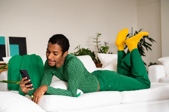 Man relaxing at home using phone