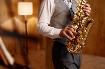 Cropped shot of young musician standing and playing saxophone