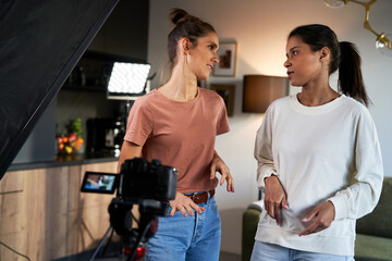 Two female women having fun while recording a video vlog