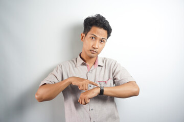 Handsome asian man wearing casual shirt In hurry pointing to watch time, impatience, upset and...