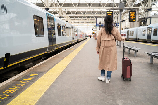 Anonymous Woman With Suitcase In Train Station