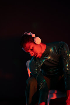 Listening to music on headphones under neon lights