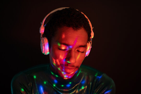 Listening to music on headphones under neon lights