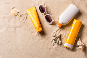 Sunblock products on sandy beach - 564932842