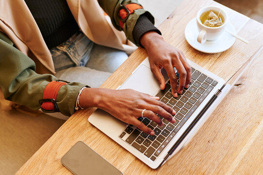 Woman using a laptop at a cafe table