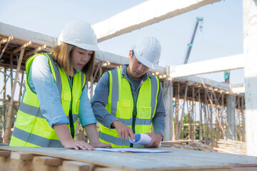 Construction engineers discussion with architects at construction site or building site of highrise building