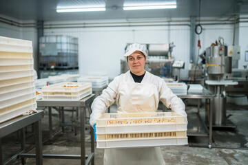 Smiling female factory employee with container