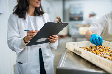 Woman controlling production of canned seafood