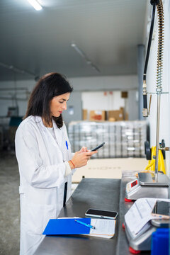 Hispanic controller browsing smartphone during work