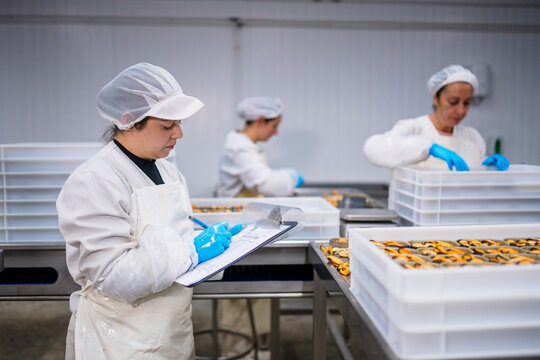Canning factory worker making notes
