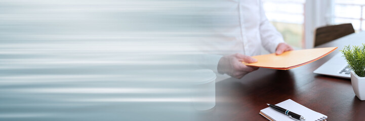 Businessman holding folder; panoramic banner