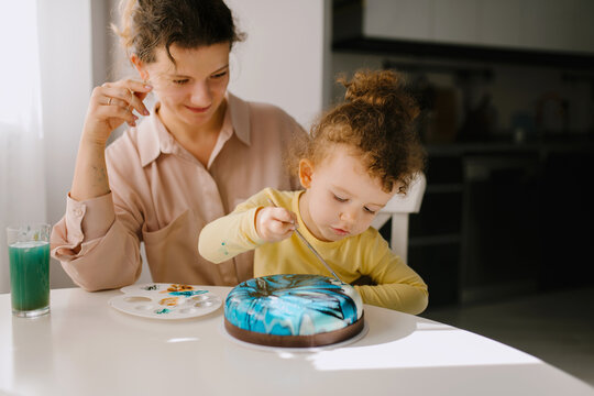 Mother And Daughter Decorating Cake