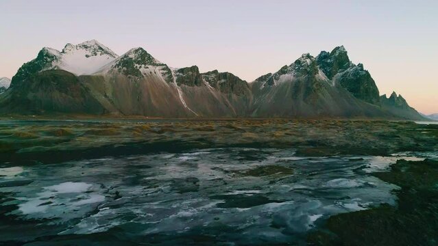 Aerial view revers over Stokksnes beach at low tide looking towards Vestrahorn Mountain