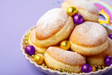 Mardi Gras King Cake Doughnuts or Donuts, Carnival Masks on Purple Background.