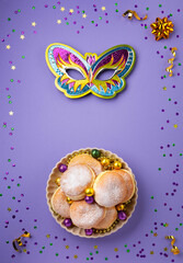 Mardi Gras King Cake Doughnuts or Donuts, Carnival Masks on Purple Background.