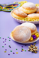Mardi Gras King Cake Doughnuts or Donuts, Carnival Masks on Purple Background.