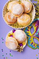 Mardi Gras King Cake Doughnuts or Donuts, Carnival Masks on Purple Background.