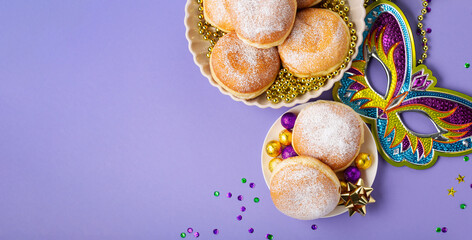Mardi Gras King Cake Doughnuts or Donuts, Carnival Masks on Purple Background. © Iuliia Metkalova